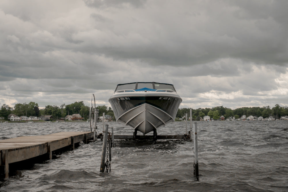 small speeder boat on a lift with dark skies behind it