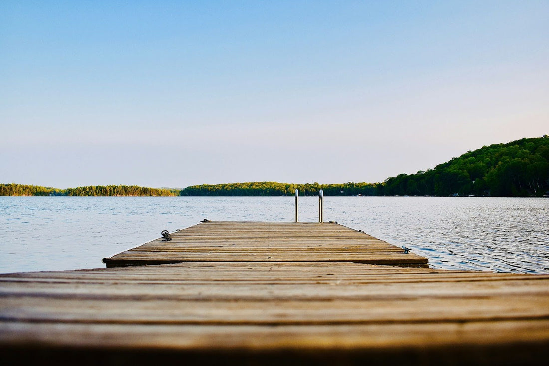 pov of a dock stretching out towards lake water